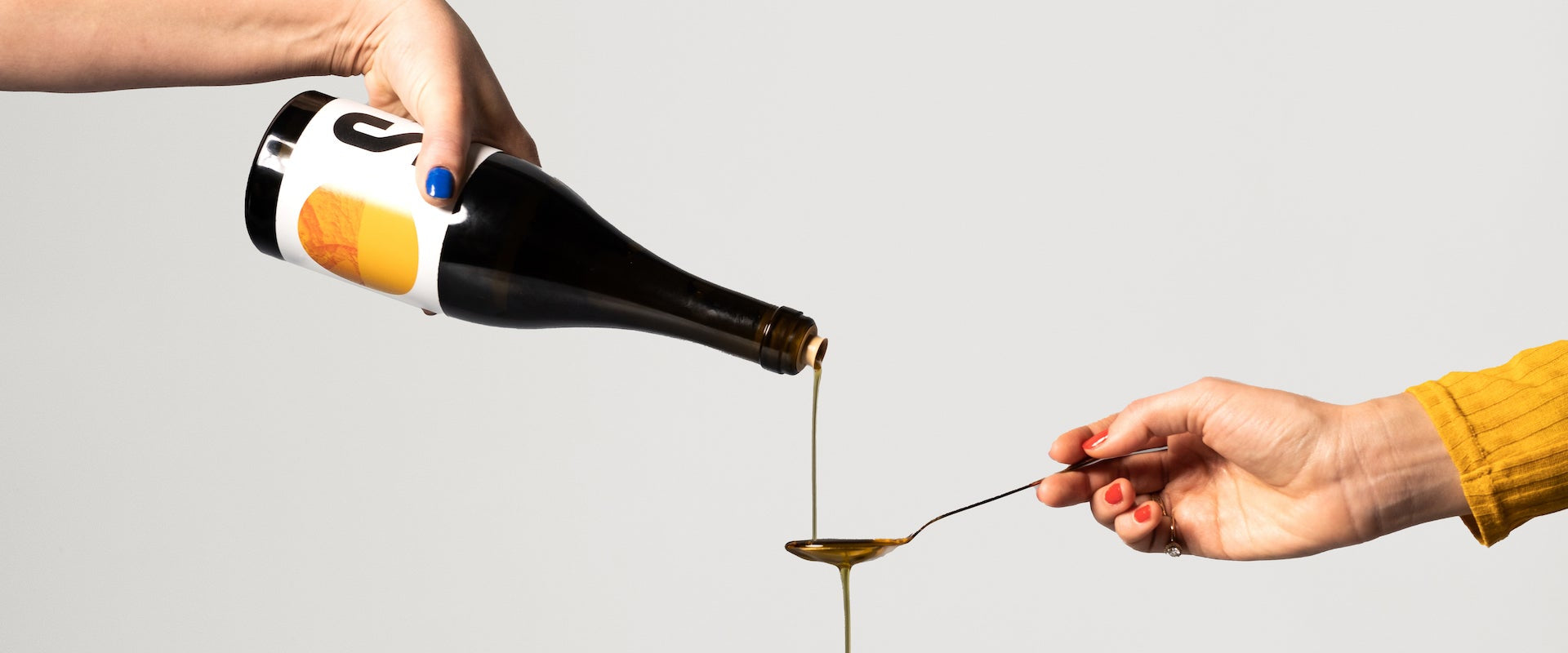 Pouring a spoon of extra virgin olive oil