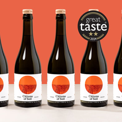 Bottles of Citizens of Soil olive oil with a 'Great Taste' award on an orange background