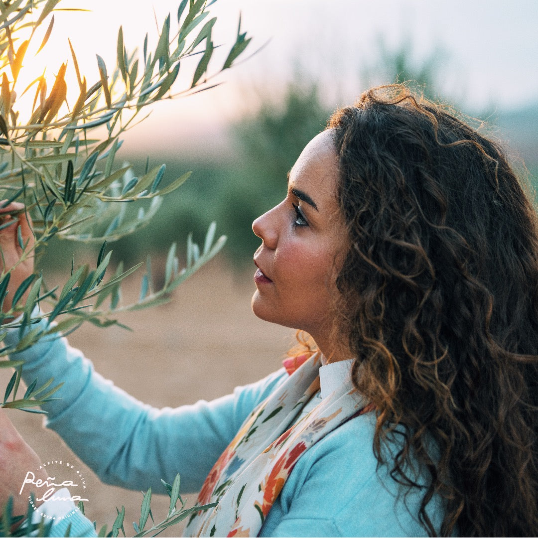 Woman holding an olive branch with a blurred natural background